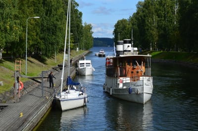 Ett par fritidsbåtar och ett litet passagerarfartyg i kanal.