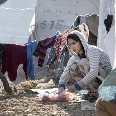 Pakolaistyttö pilkkoo ruokaa maassa Morian pakolaisleirillä.