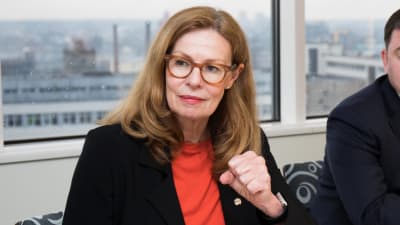 Birgitte Bonnesen vd på Swedbank sitter vid ett bord med papper framför sig.