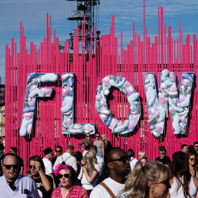 Festivaaliyleisöä Flow-kyltin edessä.