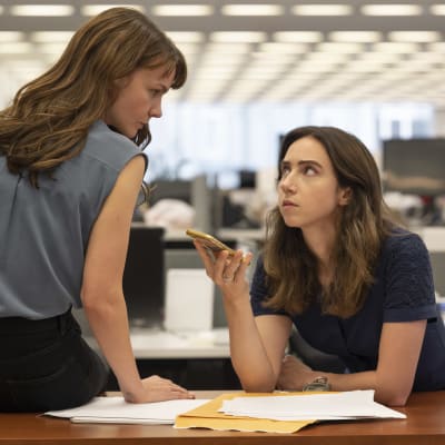 Megan Twohey (Carey Mulligan) och Jodi Kantor (Zoe Kazan) sitter vid ett bord och lyssnar på ett telefonsamtal samtidigt som de ser på varandra och ser allvarliga ut.