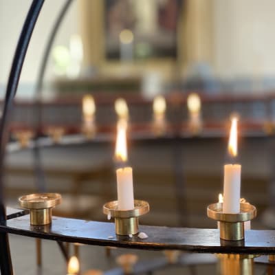 Kynttilät palavat rukouskynttelikössä.