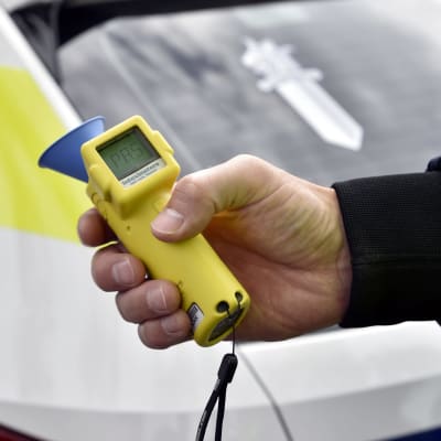 En polis håller en alkometer.