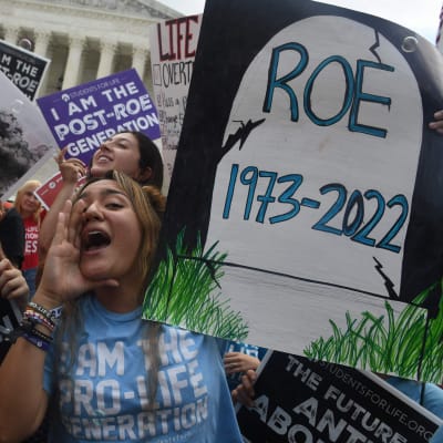 Abortmotståndare med plakat firar utanför högsta domstolen i USA.