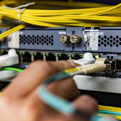 Ethernet-kaapelia laitetaan kiinni servereihin Länsi-Pohjan keskussairaalan serverihuoneessa.
