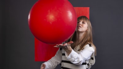 Matilda Lindblom studsar en stor, röd boll från sin hand.
