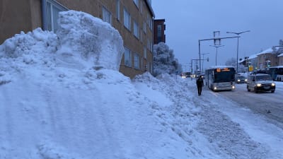Jättestor snöhög blockerar trattoaren i Helsingfors.