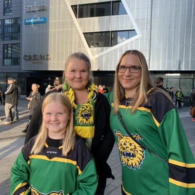Johanna Seppänen, Neea Talberg ja Lea Linnero seisovat Ilveksen pelipaidat päällä Tampereen Areenan edessä.