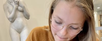 Skoleleven Elli Sandberg sitter vid ett bord i skolan i Munksnäs.