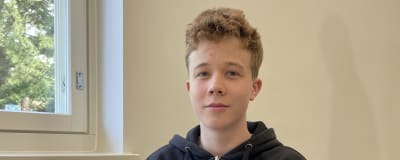 Skoleleven Paavo Andersin sitter vid ett bord i skolan.
