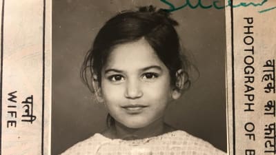 svartvitt passfoto på en liten flicka med mörkt hår och stora ögon