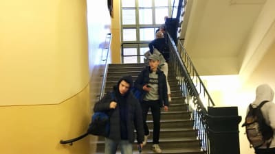 Elever som går i en trappa i grundskolan Norsen i Helsingfors.