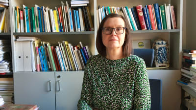 En bild på professor Helena Blomberg-Kroll i sitt arbetsrum.