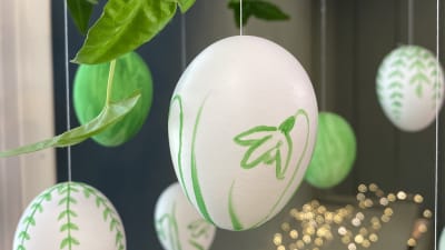 Ett målat ägg med andra målade ägg i bakgrunden