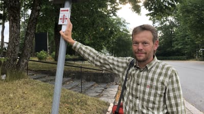 James Simpson, pekar på Sankt Olofs pilgrimsmärken, som markerar vandringsleden.