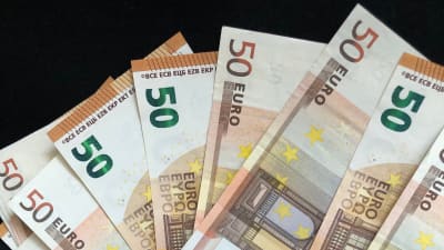 Flera 50 euros sedlar utspridda över svart bakgrund