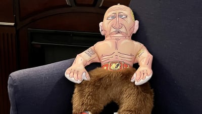 En mjuk docka som påminner om Vladimir Putin. Dockan har bruna lurviga byxor och bar överkropp.