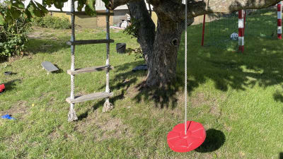 En barngunga och repstege för barn i ett äppelträd. 