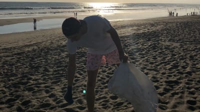 Robin Borgström plockar skräp på stranden i Bali.