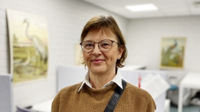 Susanne Bergström-Nyberg i ett lärarrum. Några fågelplanscher i bakgrunden.