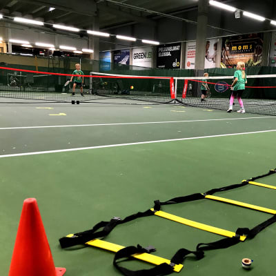 Barn som spelar tennis.