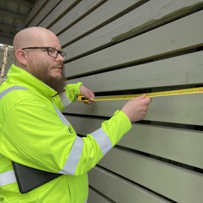 Mänttä-Vilppulan kaupungin avustava rakennustarkastaja Santtu Markkula  mittaa puuliiterin mittoja kiinteistöjen tarkastuskäynnillä. 
