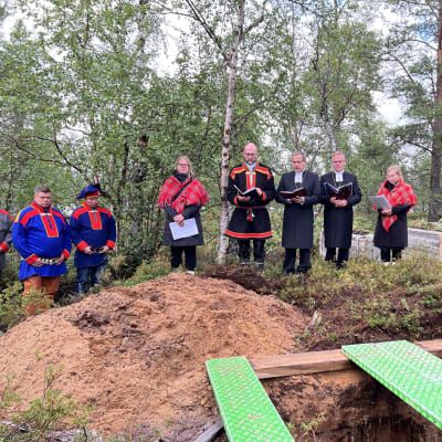 Saamelaisvainajien hautaaminen Inarin Hautuumaasaareen. Kuvassa oikealta Leo Aikio, Osmo Seurujärvi, Johanna Kinnunen, Tuomo Huusko, Jukka Keskitalo, Tapio Luoma ja Mari Valjakka. 