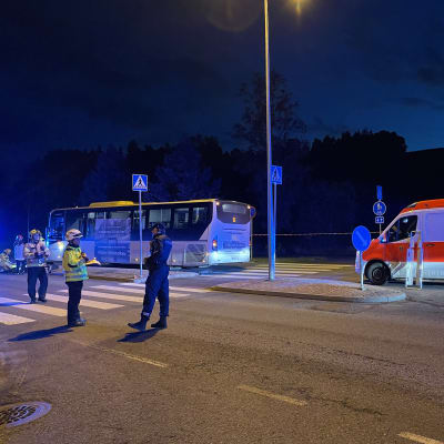 En buss och ambulans och räddningsverkets samt poliser står framför dem vid en korsning i Hirvensalo. 