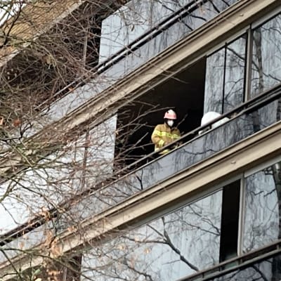 Palomies tulipalosta kärsineen kerrostalohuoneiston parvekkeella Pieksämäellä. 