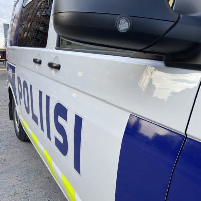 Poliisiauton kylki, jossa on sinisin kirjaimin teksti poliisi.