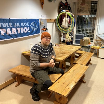 Mies istuu pöydän ääressä.