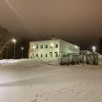Västra Nylands folkhögskolas byggnad fotograferat i mörker.