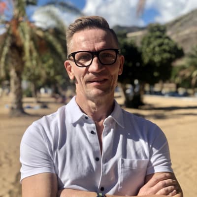 Sami Saikkonen seisoo kädet puuskassa Teneriffalla. Aurinko paistaa kirkkaana.
