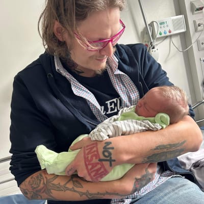 Rasmus Anderssén med sin nyfödda dotter i famnen. 