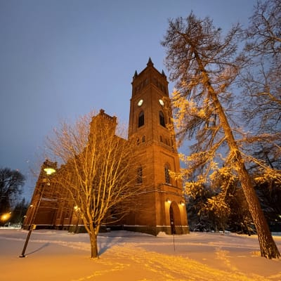 Kuvassa on Vaasan kirkko oranssiksi valaistuna.