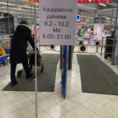 Citymarketin sisäänmenon edessä on kyltti, joka kertoo kaupan olevan auki kello 8-21.