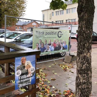 Tänk positivt, C framåt, står det på Centerns valplakat framför rivningstomt i Mariehamn