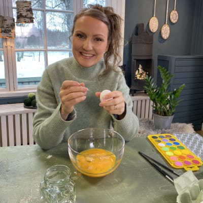 Kvinna som tömmer hönsägg för att måla med vattenfärg på dem 