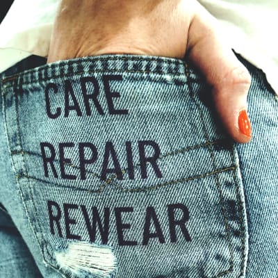 jeansficka med orden care, repair och rewear tryckta.