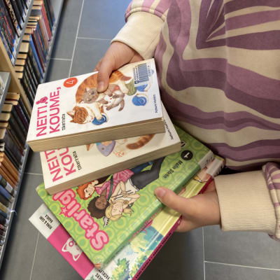 Lastenkirjoja lapsen käsissä kirjastossa