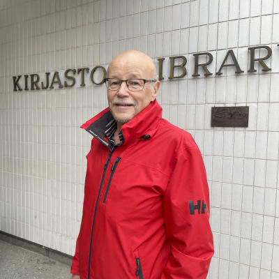 Mies seisoo kirjaston edessä