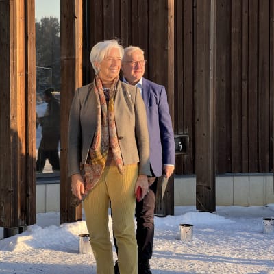 EKP puheenjohtaja Christine Lagarde ja Suomen pankin pääjohtaja ja Olli Rehn Sajoksen pihalla Inarissa ja katselevat aurinkoon päin. Taustalla näkyy Sajos.