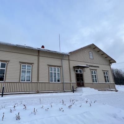 Oriveden 140-vuotias juna-asema. Kuvassa ruskea-beige puutalo, jossa isot ikkunat. Ympärillä on paljon lunta. Kuvauspäivä 30.11.2023.