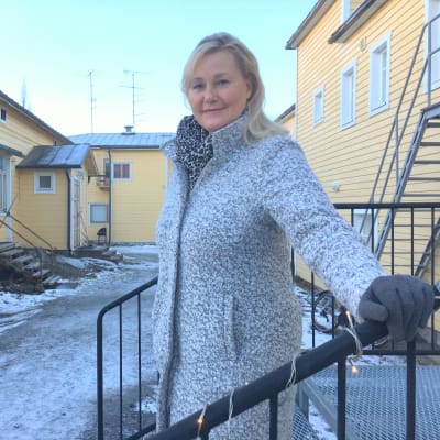 Helena Hemming står på en trappa och tittar in i kameran.