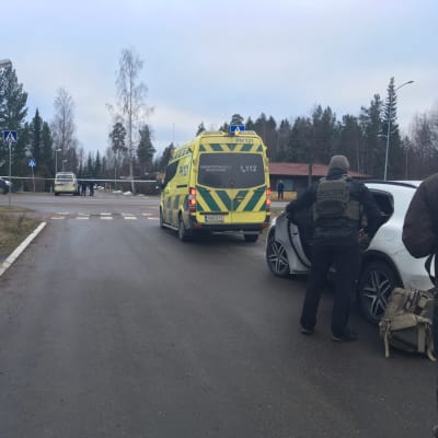 Poliser och en abulans har spärrat av ett område i Lahtis. En läkare med skottsäker väst syns på höger sida.