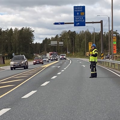 Person dirigerar trafiken på väg 51 vid avtaget till Täkter. 