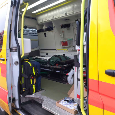 Ambulans med öppen sidodörr.