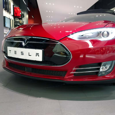 En röd Tesla-bil sedd framifrån.