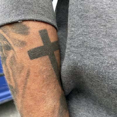 Risti-tatuointi käsivarressa.