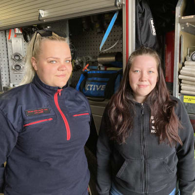 Lia Laine ja Jenni Jussila Keski-Hollolan VPK:sta seisovat paloauton vierellä.